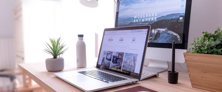 Notebook y monitor sobre un escritorio con un sitio web abierto