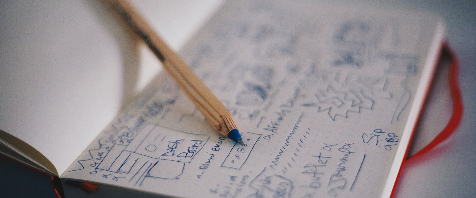 Cuaderno con bocetos de interfaz y un lápiz