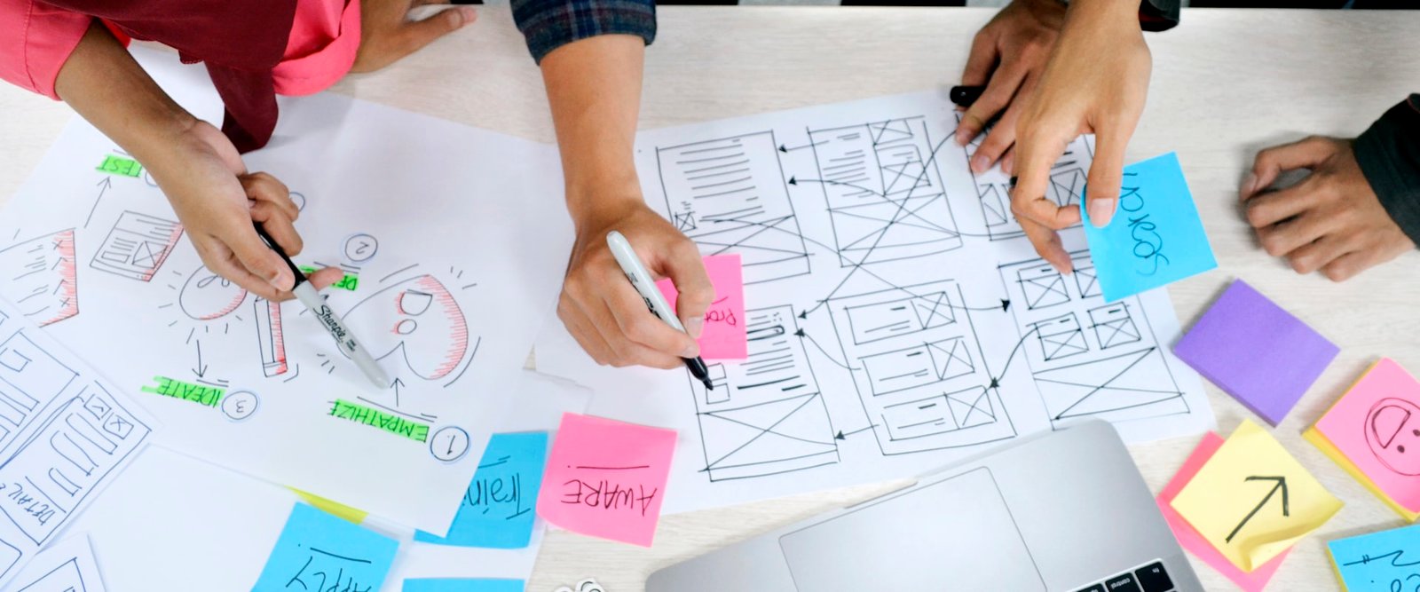 Equipo dibujando wireframes con notas adhesivas